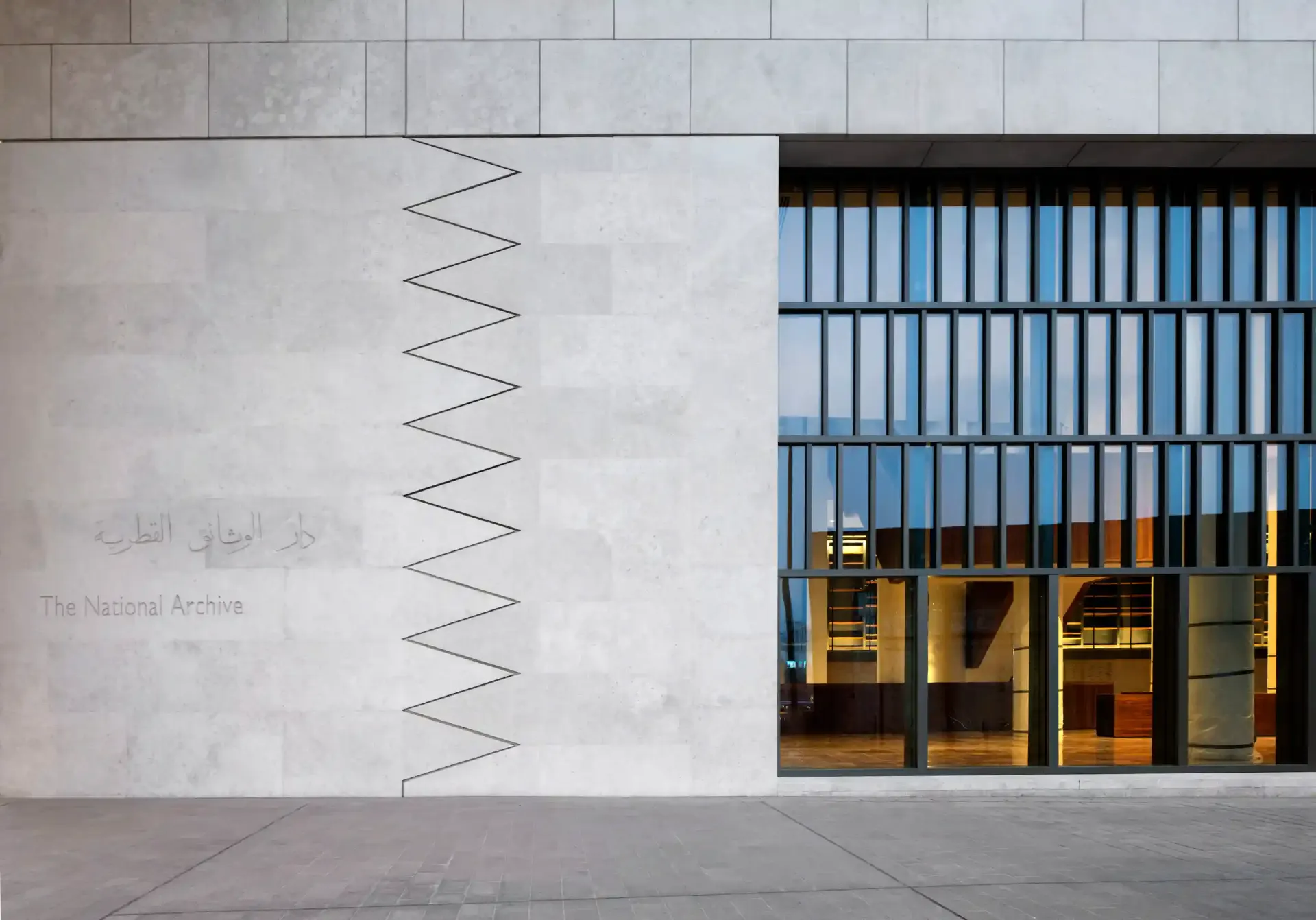 The National Archive in Doha, Qatar — layered stone volumes under clear desert light