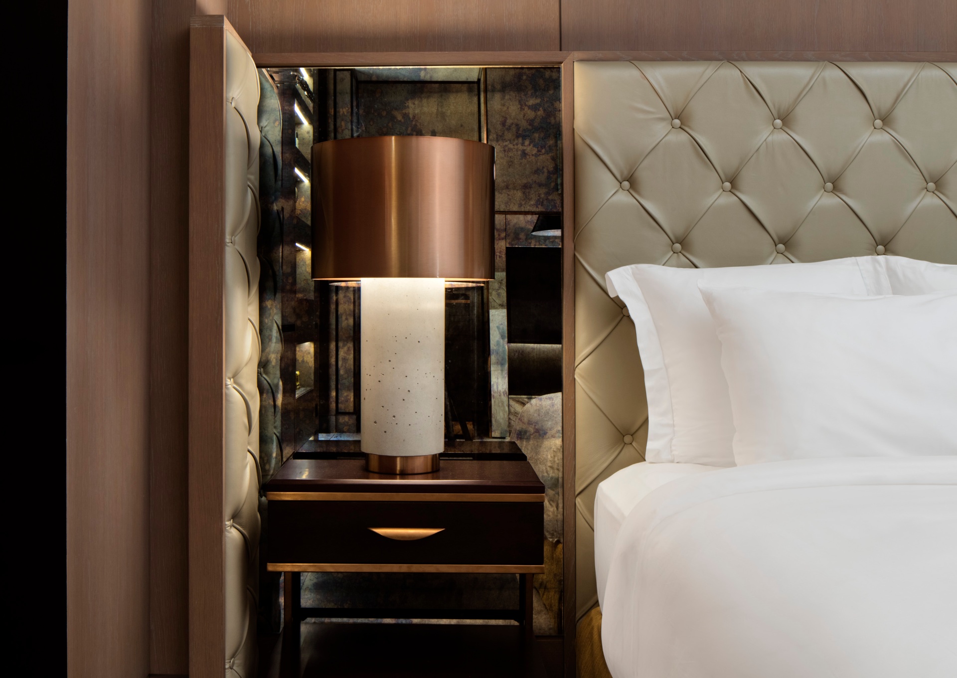 Hotel suite living area with layered lighting and a retained window view
