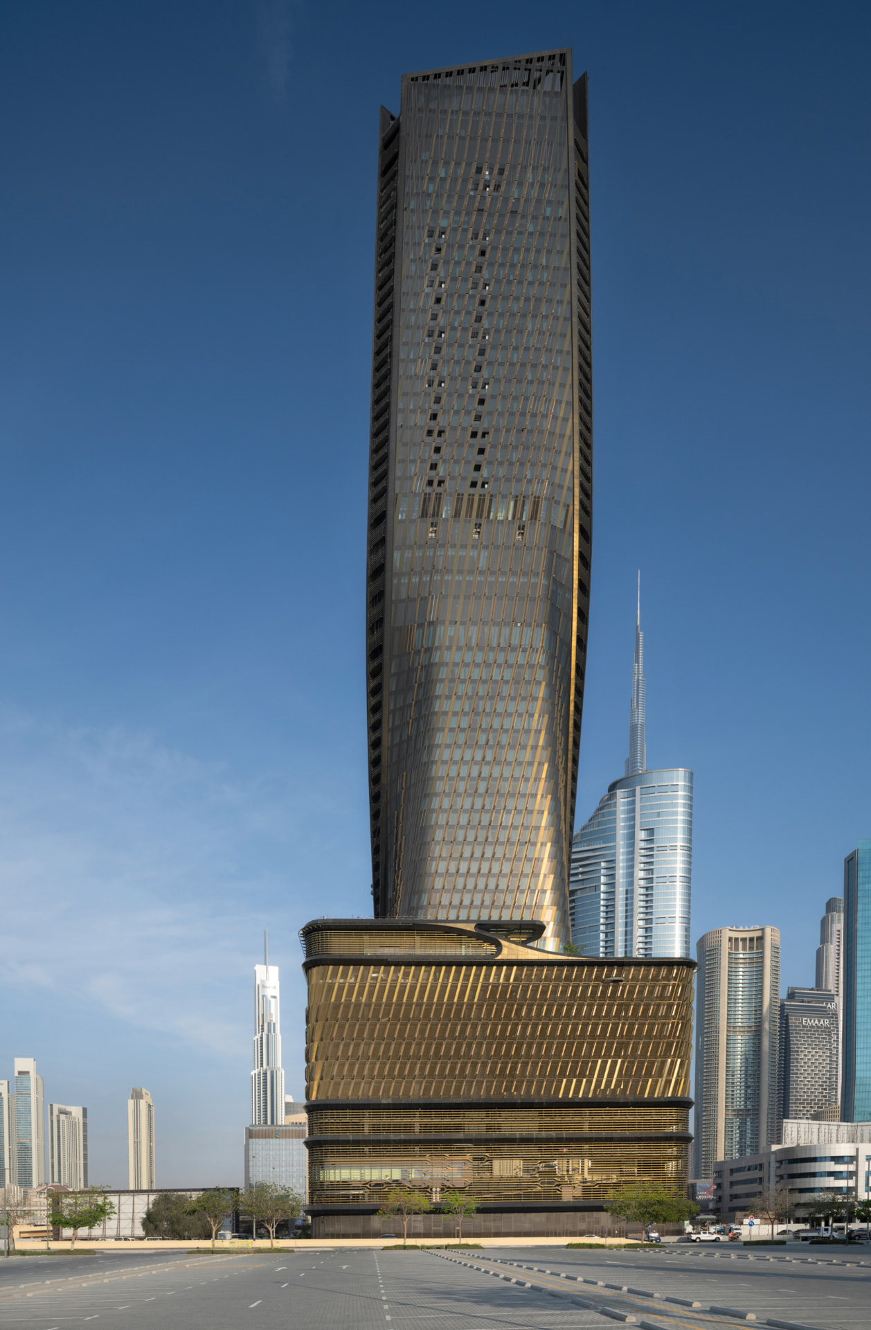 Wasl Tower, Dubai — low-angle base view with Burj Khalifa on the skyline