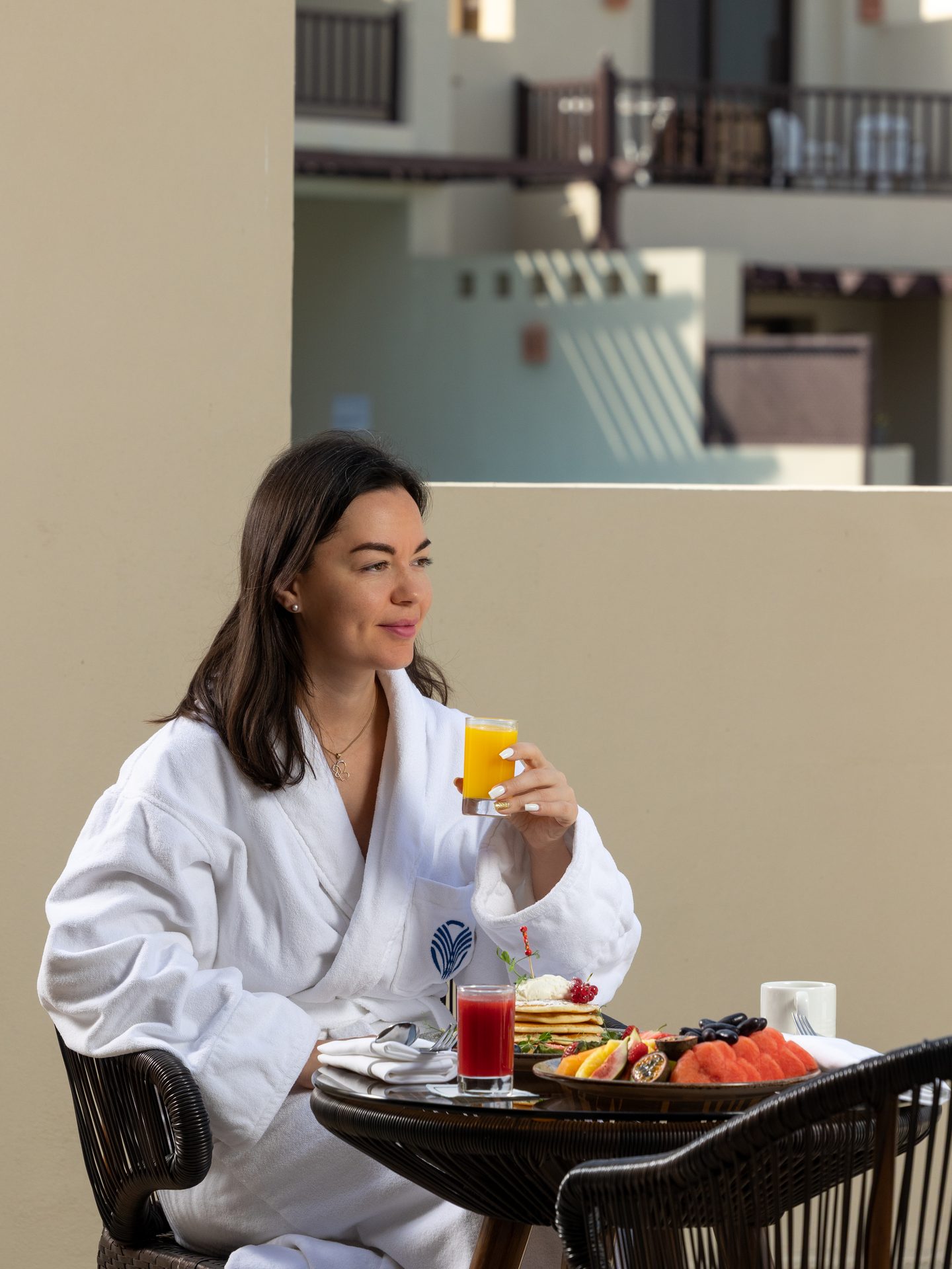 Terrace breakfast lifestyle scene with a guest figure in soft morning light