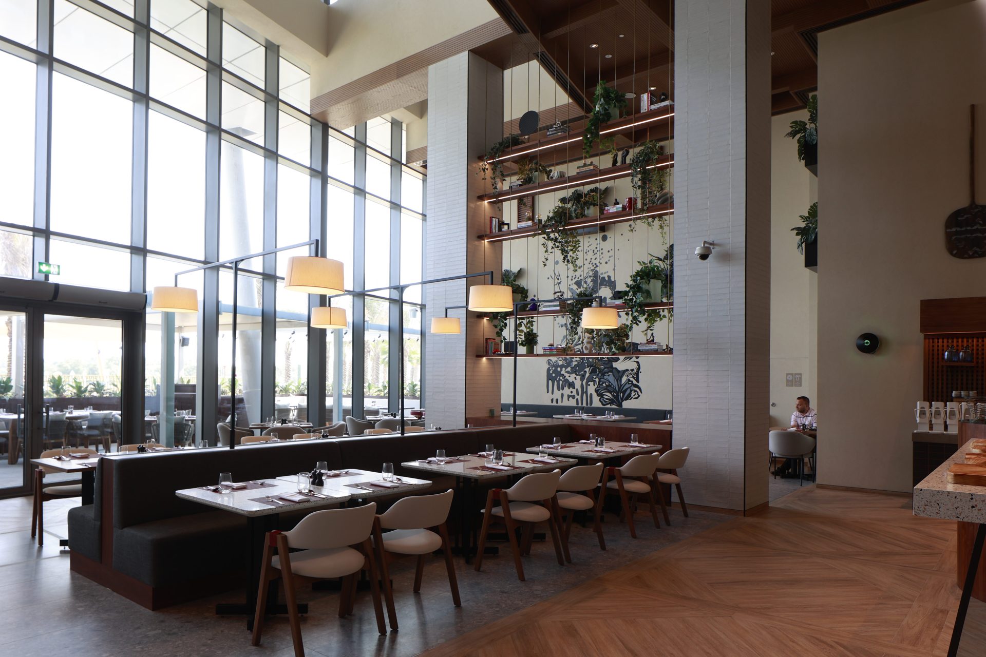 Terra restaurant at Rotana Ras Al Khaimah before the refresh — blown-out window light and muted interior tones across the banquette seating