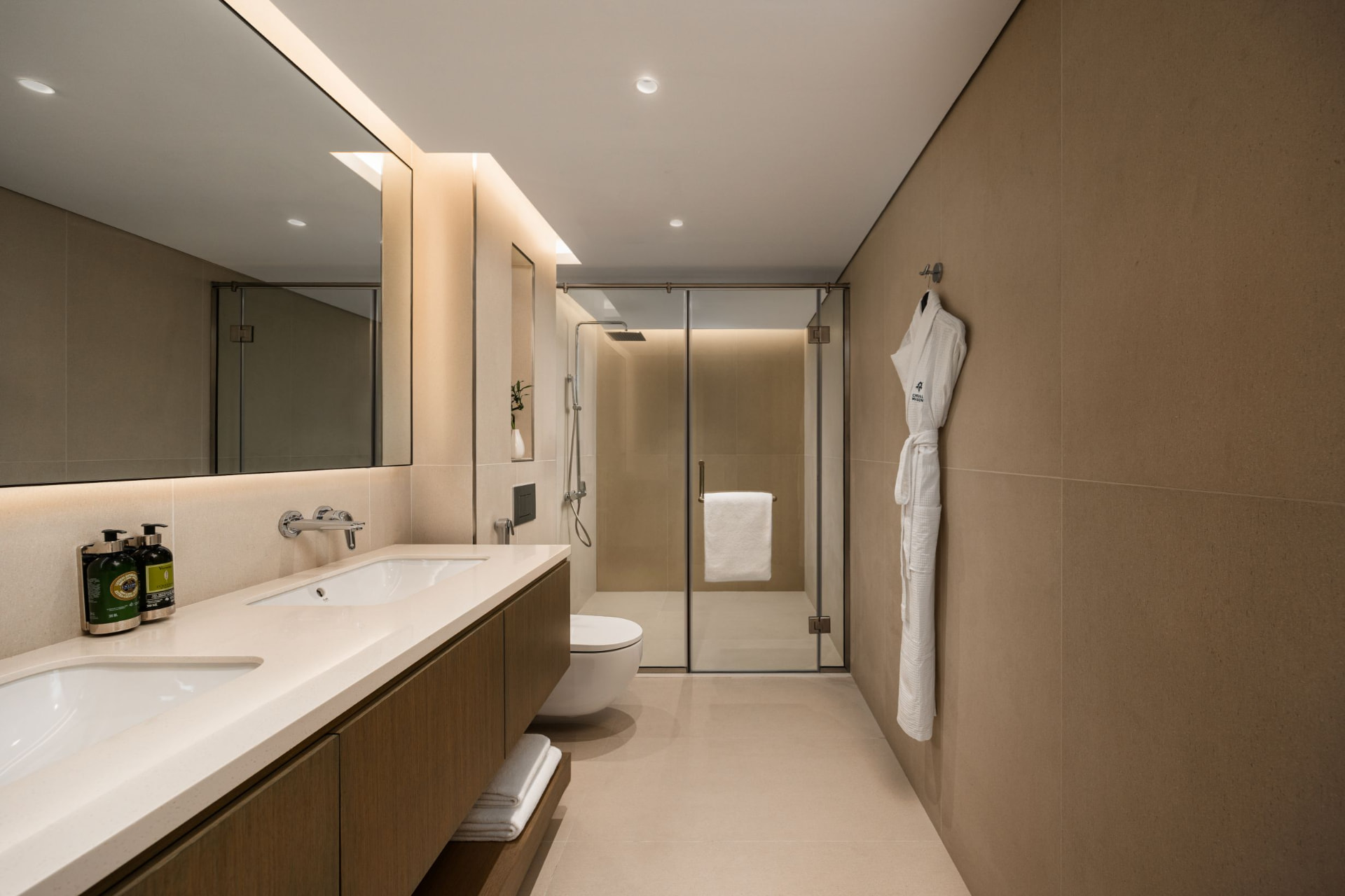 Cheval Maison The Palm master bathroom after the photography refresh — warm stone tones, clean whites and evenly lit twin vanity, robe and glass walk-in shower