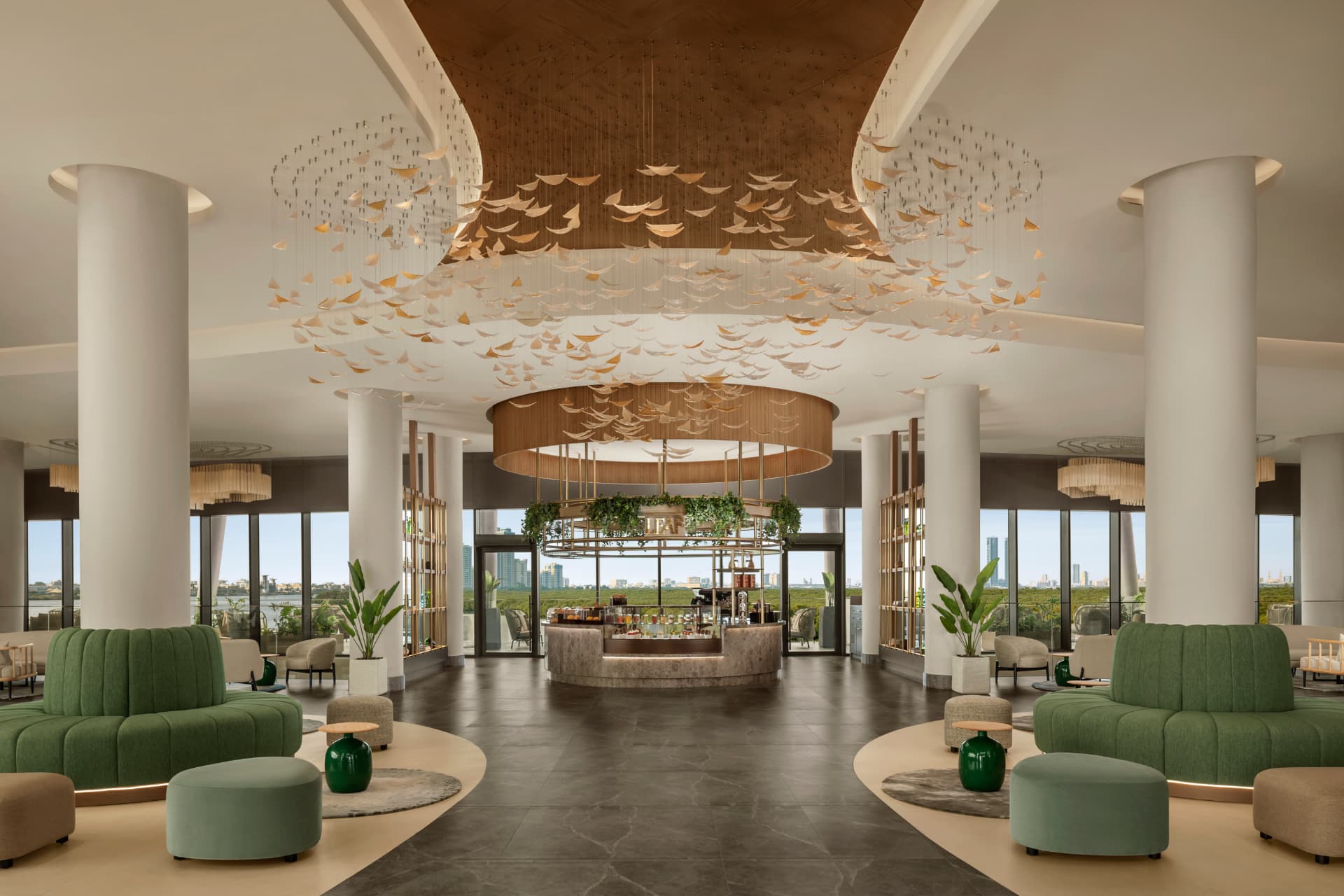 Grand hotel lobby at Conrad Dubai with sweeping ceiling installation, green velvet seating and panoramic city views