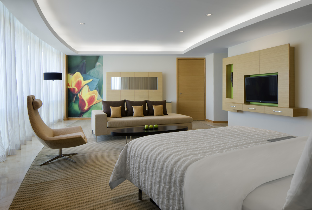 Le Méridien Cairo suite living area with lounge seating, patterned rug and daylight from the terrace doors