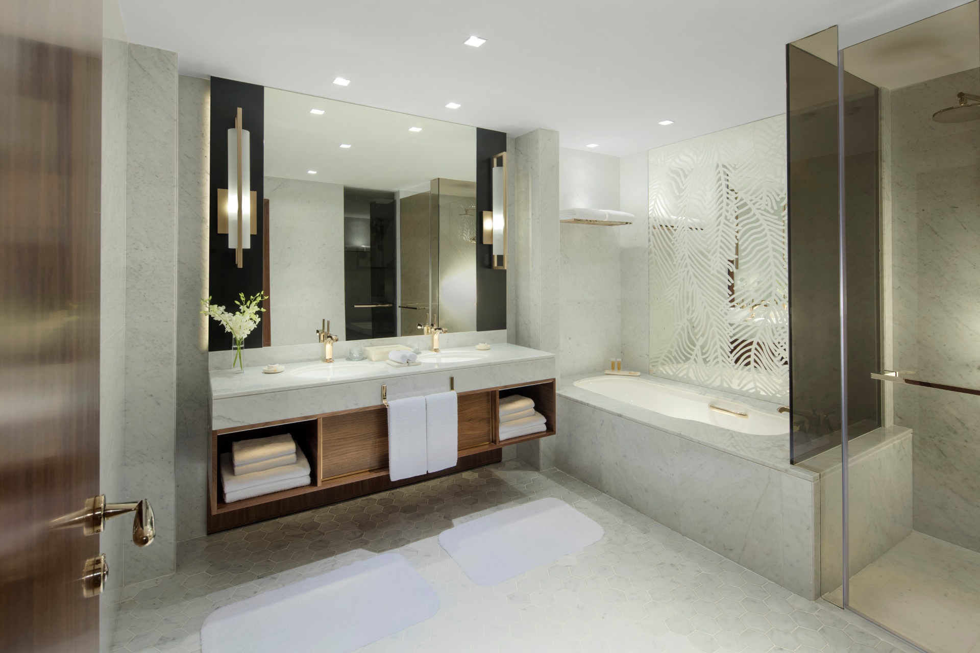 Marble bathroom suite at Grand Hyatt Doha with twin vanity, mirrored wall and soft recessed lighting