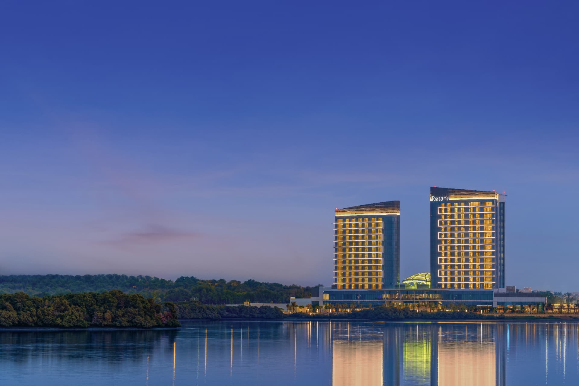Rotana Ras Al Khaimah, The Mangroves — resort towers photographed at dusk with interiors lit