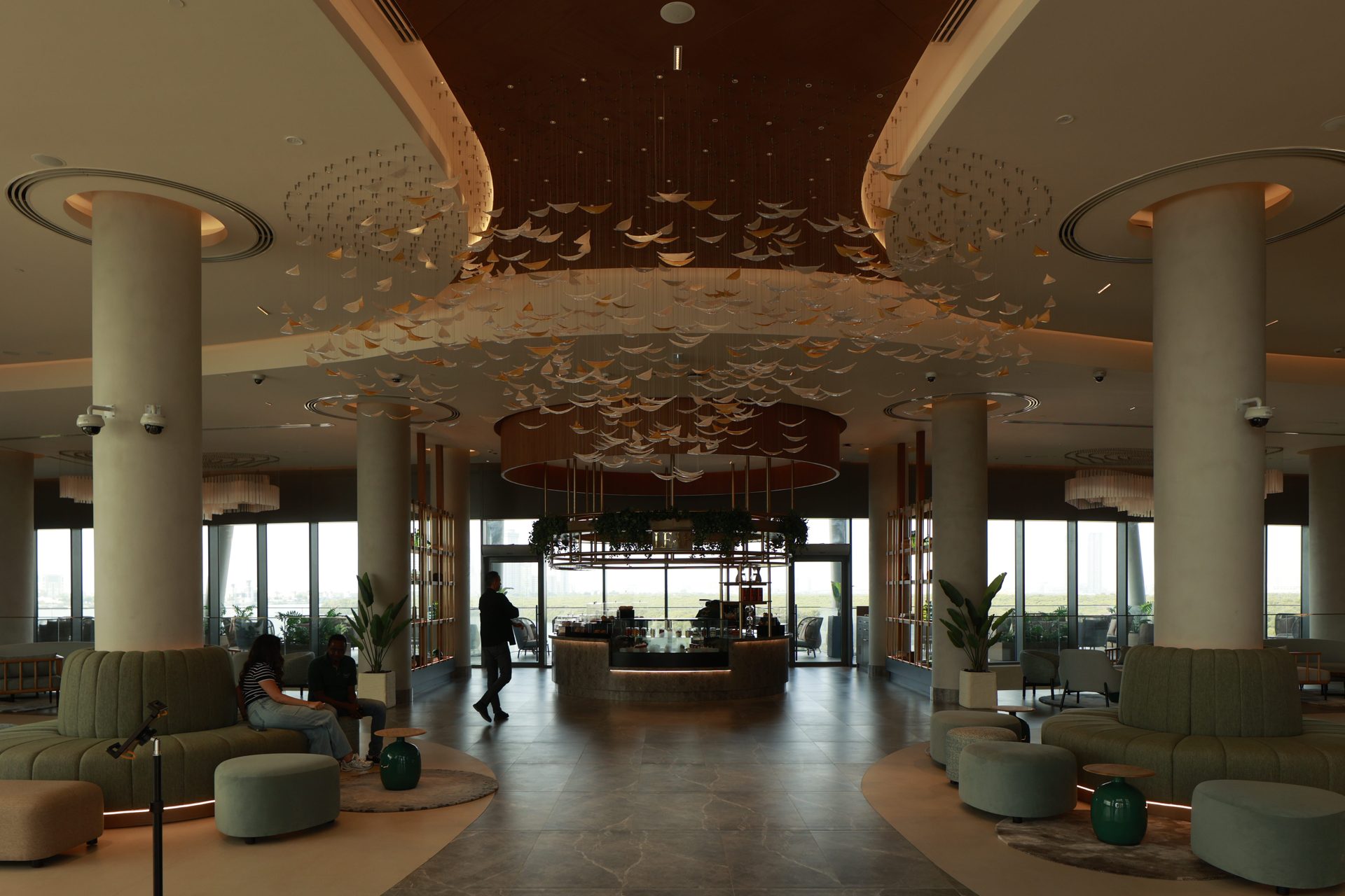 Rotana Ras Al Khaimah lobby before the photography refresh — off-centre framing, warm colour cast and uneven exposure across the suspended leaf installation and green lounge seating